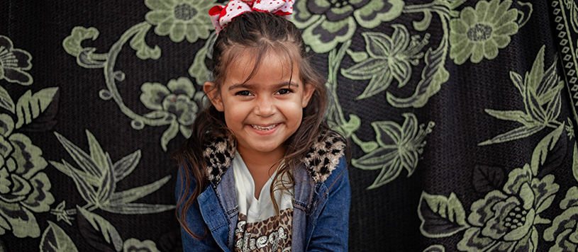 a young girl smiles at the camera