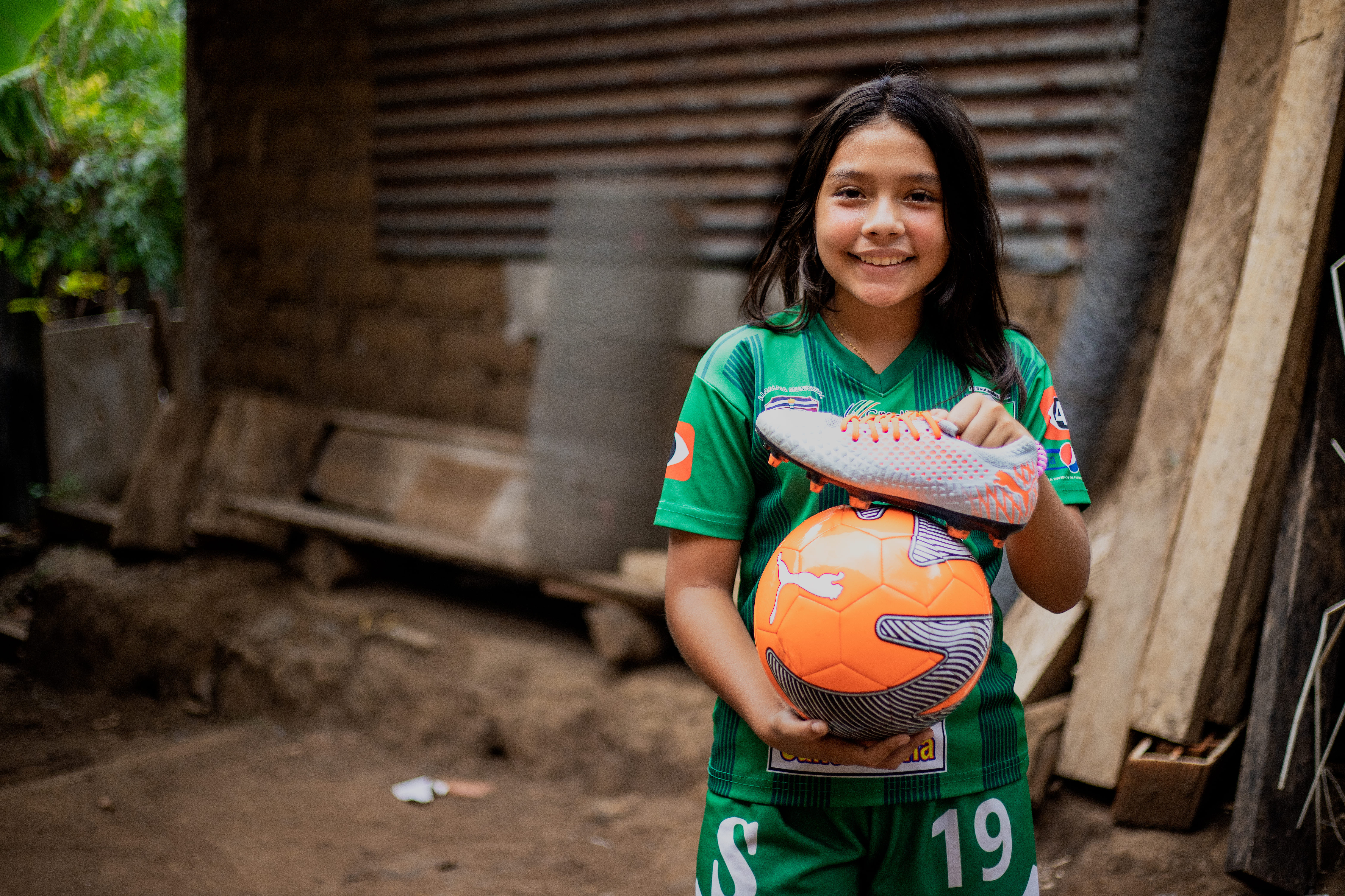 Girl holding soccer ball and cleat