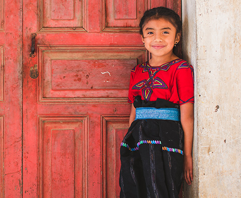 a child stands in front of a wall