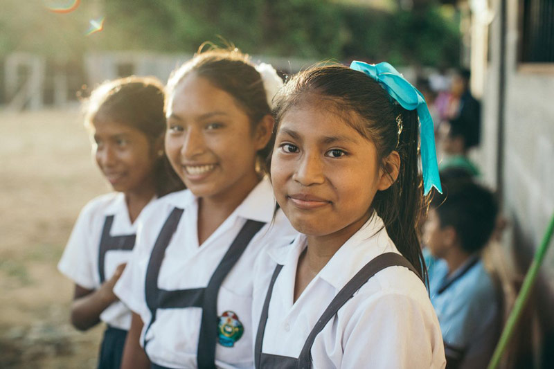 Girls smile while enjoying free time at their child development center